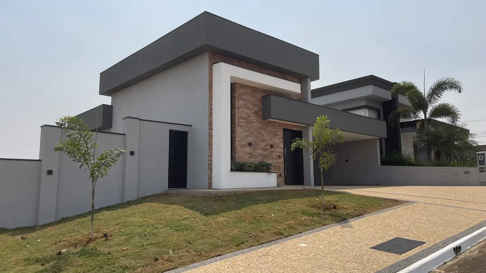 Residência R.S. — Fachada contemporânea com revestimento em tijolo aparente em Americana SP